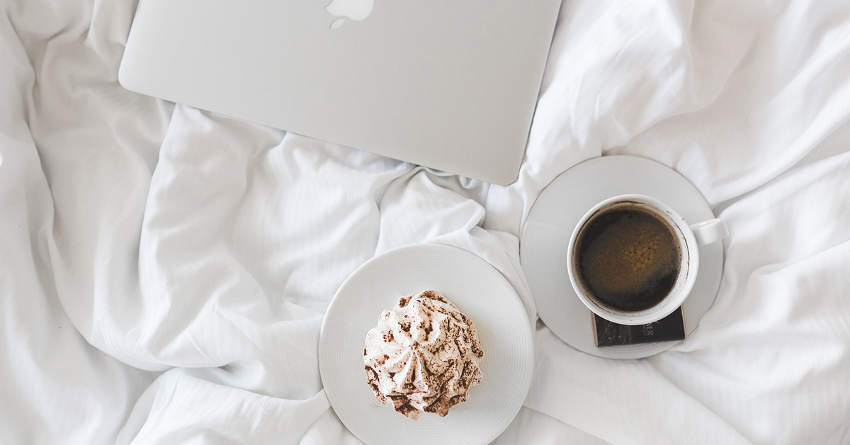 kava a sladkost na posteli pri macbooku